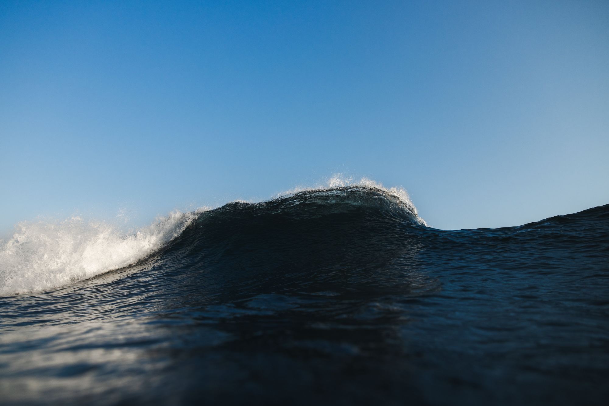 Wave cresting against blue sky